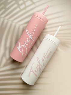 two pink and white travel mugs sitting on top of each other