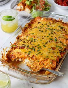 a glass casserole dish filled with lasagna and topped with fresh herbs