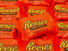 reese's peanut butter candy bars are stacked on top of each other in orange wrappers