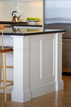 a kitchen island with stools in front of it and an app on the phone