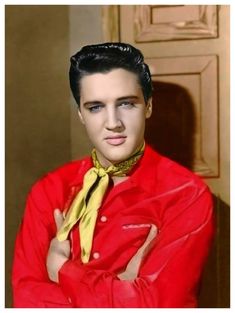 elvis presley wearing a red shirt and yellow tie with his arms crossed in front of him