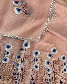 an embroidered pink dress with blue flowers on it