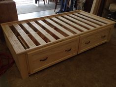 a wooden bed frame with two drawers on each side