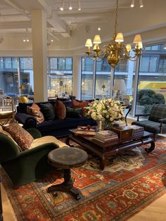 a living room filled with furniture and lots of windows next to a rug on the floor