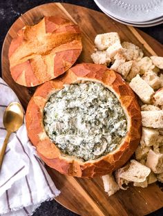 a wooden plate topped with bread and spinach dip