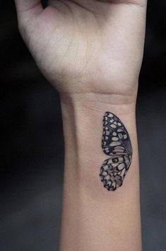 a black and white butterfly tattoo on the left inner wrist, which is attached to an armband