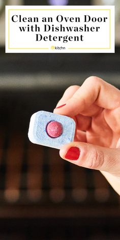 a woman's hand holding an over - door dishwasher detergent