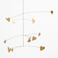 gold hearts hanging from a wire against a white background