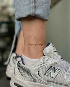 a woman's foot with a small tattoo on her left ankle and the word, love