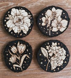 four decorated cookies sitting on top of a wooden table