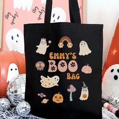 a black bag with halloween stickers on it sitting next to other decorations and pumpkins