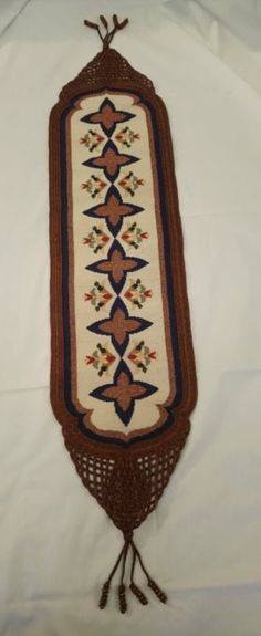 an old rug is laying on a white sheet with tassels and beading