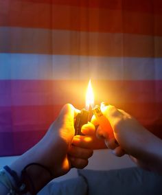 two hands holding a lighter in front of an american flag