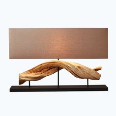 a table lamp made out of driftwood with a shade on the top and bottom