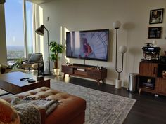 a living room filled with furniture and a large flat screen tv mounted to the wall