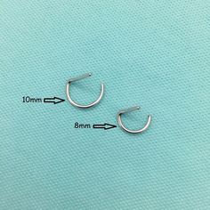 pair of small silver hoop earrings with measurements for each ear length and width on a blue background