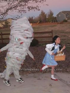 two children dressed up as alice and the white rabbit, one holding a basket while the other