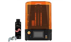 an orange 3d printer next to a black bottle