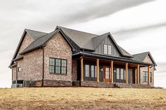 a large brick house sitting on top of a dry grass field