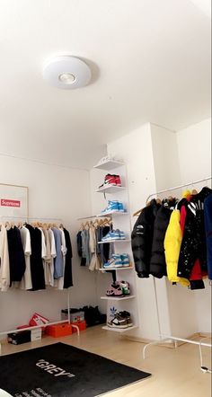 a room filled with lots of clothes and shoes on shelves next to a black rug