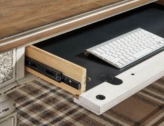 a computer desk with a keyboard and mouse on top of it next to a rug