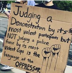 a protester holding a sign that reads judging a demonstration by its most violent participants