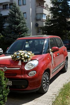 a small red car with flowers on the front