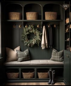 a bench with baskets and wreath on it in front of a coat rack filled with coats