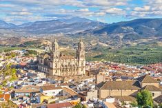 an aerial view of a city with mountains in the background