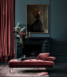 a living room with a red couch and a painting on the wall next to it