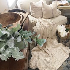 a living room filled with lots of furniture and pillows on top of a rug next to a wooden table