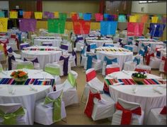 many tables and chairs are decorated with colorful ribbons