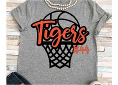 a t - shirt with the word tigers on it and a basketball in the hoop