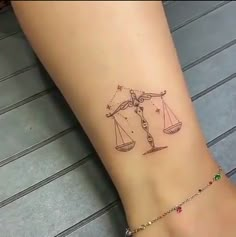 a woman's foot with a tattoo on it that has an image of a lady justice