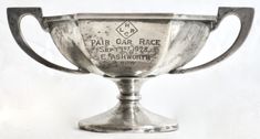 an old silver cup with the words fair car race on it