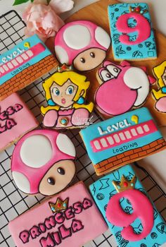 some cookies that are shaped like mario and princess peaches on top of each other