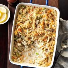 a casserole dish with chicken and vegetables in it on a wooden table next to a cup of tea