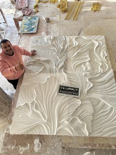 a woman standing next to a white sculpture on top of a stone slab in a building