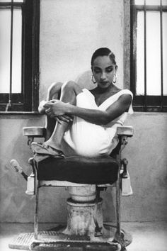 a black and white photo of a woman sitting in a chair