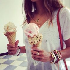 a woman holding two ice cream cones in her hands