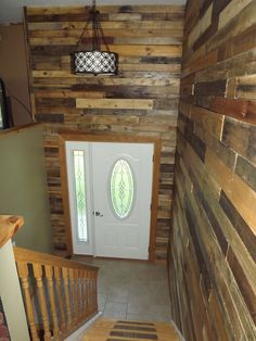 an entry way with wood planks and a door leading to the second floor area