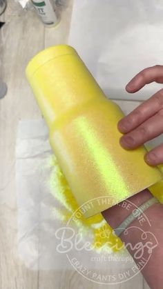 a person holding a yellow roll of toilet paper