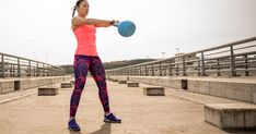 a woman holding a blue frisbee in her right hand and wearing leggings