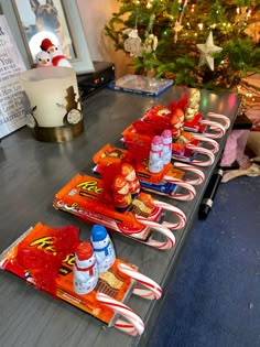 candy bars are lined up on a long table in front of a christmas tree and other decorations