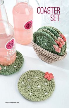 three crocheted coasters with flowers on them next to a bottle of water