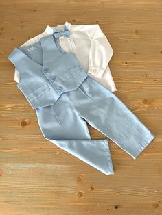 ✿ABOUT THIS SUİT ✓This luxurious four-piece light blue suit set creates a stylish and personalized look for your little one's special occasion. ✓The set includes a pair of optional suspender trousers available in two different models, a silk alpaca fabric vest, a bow tie, and a shirt with two fabric options of white linen or cotton, also available in two different models.  ✓The trousers feature an elastic waistband for a comfortable fit and adjustable straps for the perfect fit. Made of soft and Fitted Sets For First Communion In Spring, Spring Fitted Sets For First Communion, Spring First Communion Fitted Sets, Elegant Blue Sets For Baptism, Light Blue Blazer Outfit, Alpaca Fabric, Blue Blazer Outfit, Light Blue Blazer, Light Blue Suit