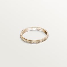 a rose gold ring with white diamonds on the side and an inscription that reads cartier