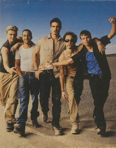 five men are standing together in the desert