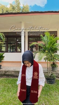 a woman wearing a red scarf standing in front of a building with palm trees and potted plants