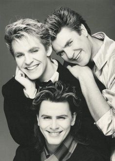 three young men are posing for a black and white photo with their arms around each other